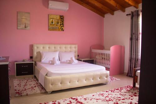 a bedroom with a white bed and pink walls at CASTLE View SERENITY -- BERAT in Berat