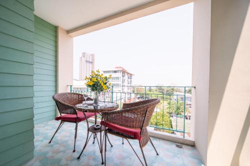 a balcony with a table and chairs with a view at Shamrock Hotel Pattaya in Pattaya South