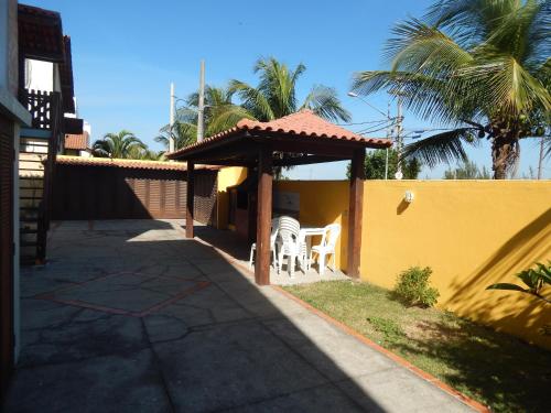 a gazebo with a table and chairs in a yard at Casinha no Paraiso in Arraial do Cabo