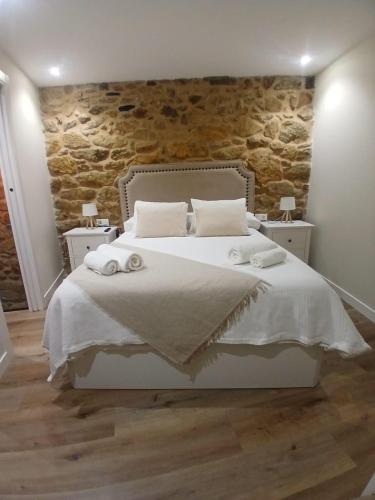 a bedroom with a bed with two towels on it at Casa o Sabio in Fisterra