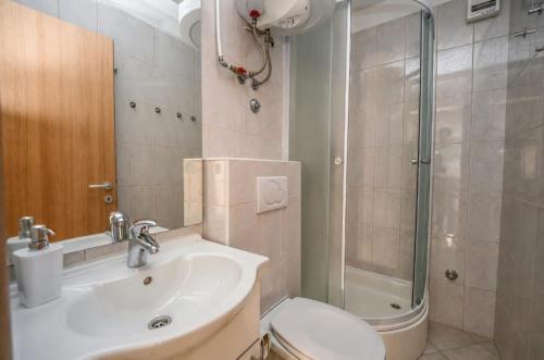 a bathroom with a toilet and a sink and a shower at Mikuljan Apartments with Pool-5 min to Beach & Private Parking Included in Stobreč