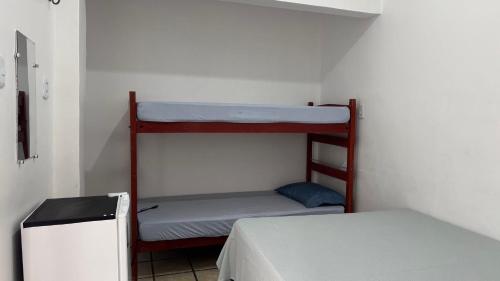 a room with two bunk beds and a refrigerator at Pousada Point da Nanda in Juazeiro do Norte