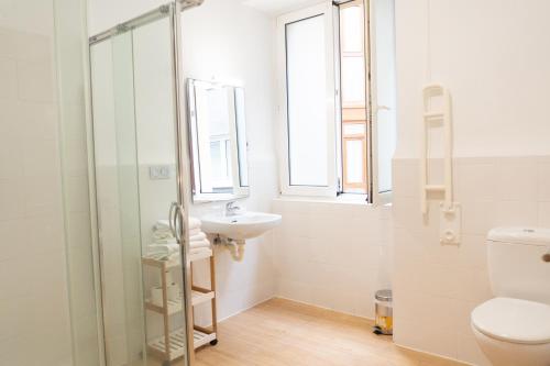 a bathroom with a sink and a toilet and a window at Musika Plaza in Zarautz