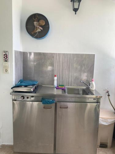 a kitchen with a sink and a clock on the wall at Το σπίτι της Ελένης in Vlakhiá