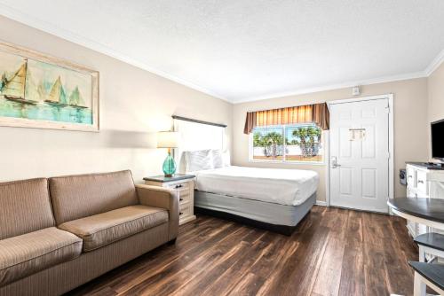 a hotel room with a bed and a couch at Club Destin Condos in Destin