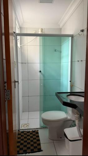 a bathroom with a toilet and a glass shower at Hotel Sol Brasil in Fortaleza