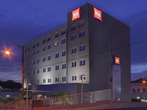 a hotel with neon signs on the side of it at ibis Jaboticabal in Jabuticabal