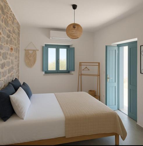 a bedroom with a large bed with blue windows at Ελαιόλιθοι Μάνη Villas in Oitylo