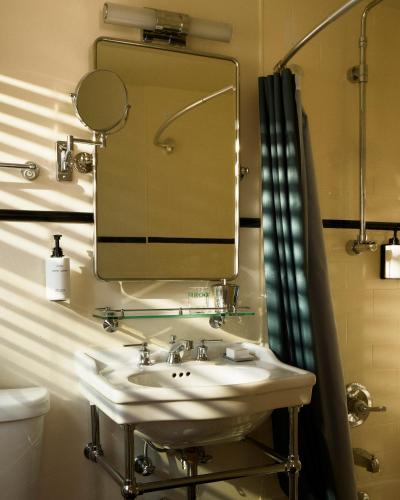 a bathroom with a sink and a mirror at Perroquet Hotel in Fort Lauderdale