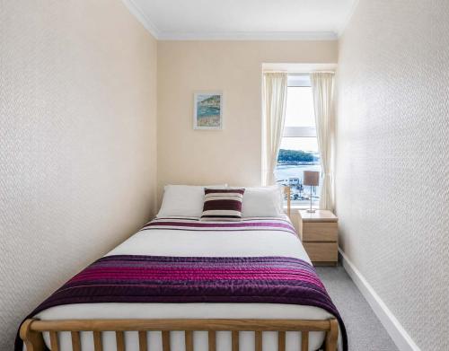 a small bedroom with a bed with a window at Lady Mary Sea View in Rothesay