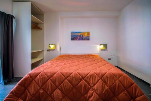 a bedroom with a bed with an orange bedspread at El Bahia Gaeta in Gaeta