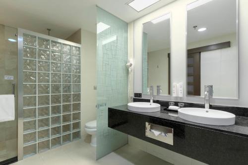 a bathroom with two sinks and a mirror at Riu Plaza Guadalajara in Guadalajara