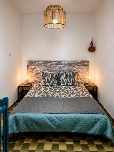 a bedroom with a large bed and two lamps at Bluemoon Campinho Rooftop & BBQ near Alqueva in Campinho