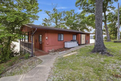 a red house with a tree in front of it at Emerald waters in Camdenton