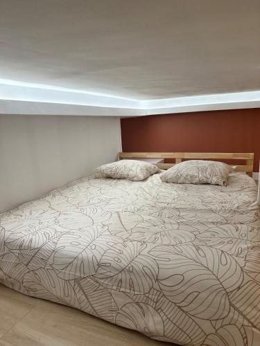 a bedroom with a large bed with a blanket at Le Cocon du Royat Palace in Royat
