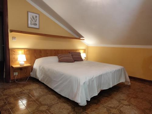 una camera da letto con un letto con due cuscini sopra di Appartamenti Alpi Graie - Cantoira a Cantoira