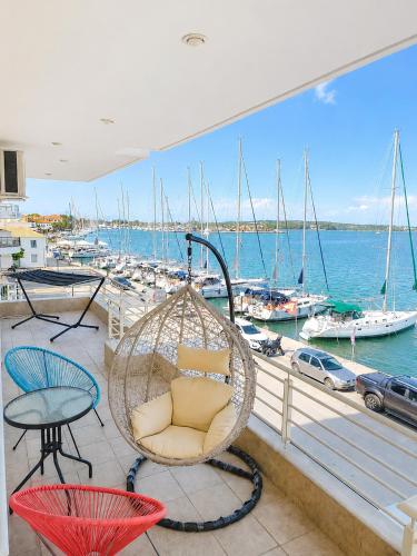 a porch with a swing and a marina with boats at AB Preveza Apartments-15 Meters Over the Sea Attic & Alexander's the Great Executive Suite in Preveza