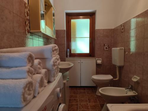 un bagno con lavandino, WC e finestra di Appartamenti Alpi Graie - Cantoira a Cantoira