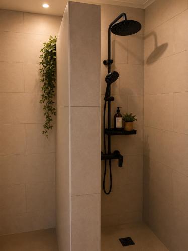 a shower with a shower head in a bathroom at Bluemoon Campinho Rooftop & BBQ near Alqueva in Campinho