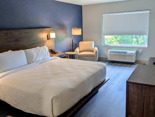 a bedroom with a bed and a chair and a window at The Hotel Vue in Natchez
