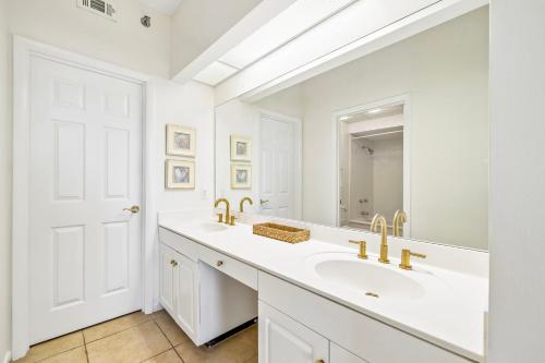 a white bathroom with a sink and a mirror at HP 124 Condo by 30A Escapes in Rosemary Beach