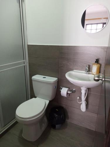 a bathroom with a toilet and a sink at Nirvana Home Calima Darien in Darién