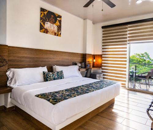 a bedroom with a large bed and a balcony at Hotel Natural Hill's by H&R in Villeta