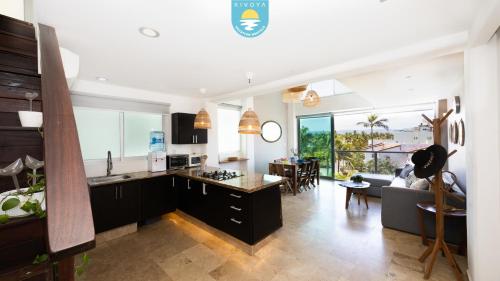 a kitchen and living room with a couch and a table at Terra 12 Penthouse Private Shallow Pool & Beach Access in Nuevo Vallarta