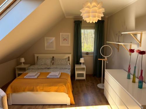a bedroom with a bed with an orange blanket at Dom w Sąpach in Sąpy