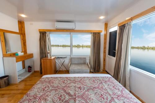 a bedroom with a bed and a large window at Crociera sul Nilo Luxury in Luxor