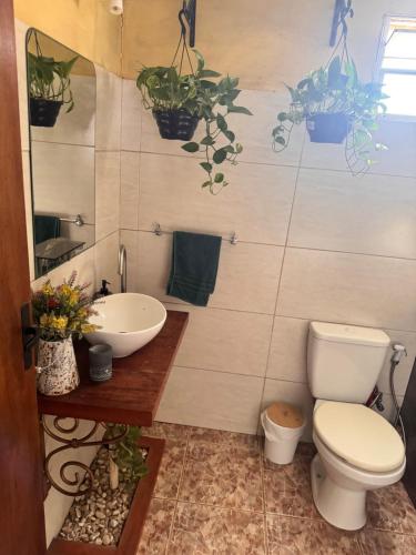 a bathroom with a toilet and a sink and potted plants at Casa en Chuy in Chuy
