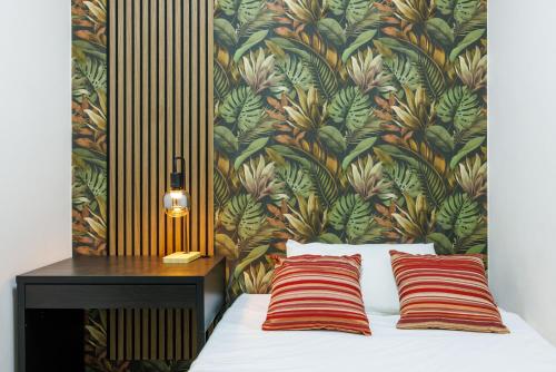 a bed with two red striped pillows next to a wall at Catherine's Home Central Apartment in Taormina