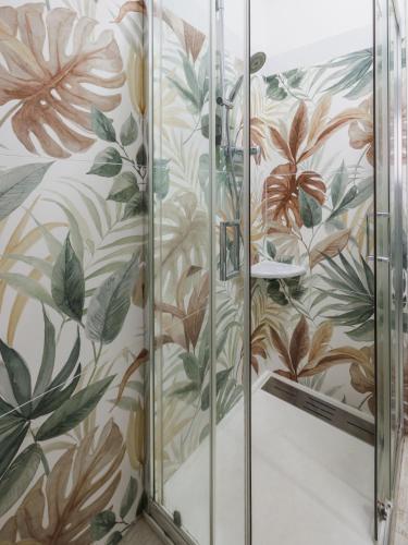 a shower stall with floral wallpaper in a bathroom at Catherine's Home Central Apartment in Taormina