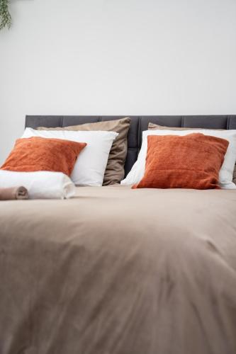 a bed with four pillows on top of it at Alvastay - Cozy studio in Haaltert