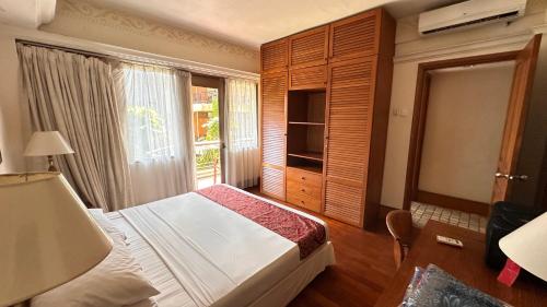 a bedroom with a bed and a large window at Nattaya at the Jayakarta Bali in Seminyak