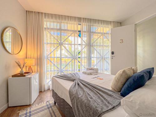 a bedroom with a bed and a large window at Wafeh Guest House - Fleming - Bar & Jardim in Belo Horizonte