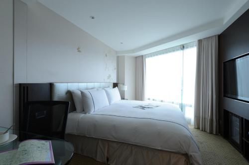 a hotel room with a bed and a television at K Hotel Taipei Dunnan in Taipei