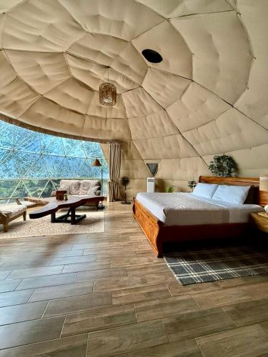 a bedroom with a bed and a large ceiling at Tropical Escape Domes in Guápiles