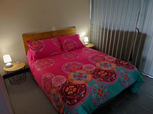 a bedroom with a large bed with pink sheets at "La maison fleurie" Sud Vendée 85 in Avrillé