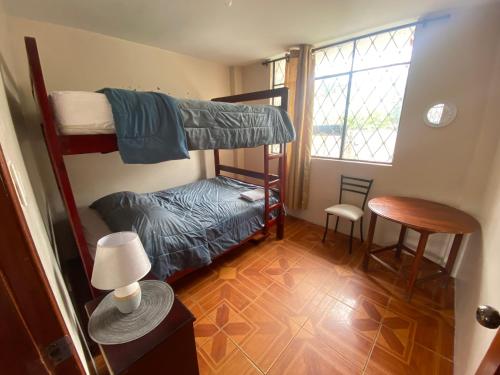 a bedroom with two bunk beds and a table at El refugio de Lolita in Loja