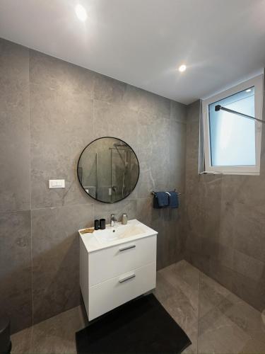 a bathroom with a white sink and a mirror at Palm Blues in Vodice