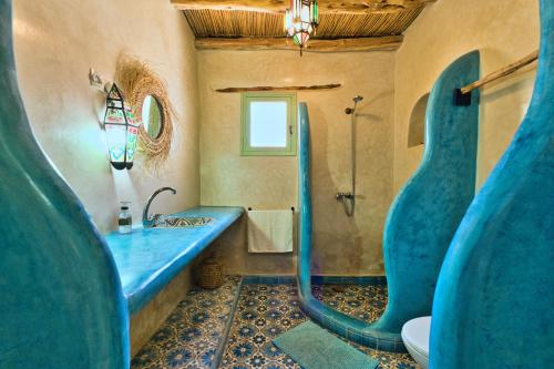 a bathroom with a blue sink and a shower at Villa Nouran Beldi in Essaouira