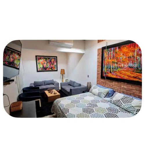 a living room with a bed and a painting on the wall at Casa totalmente amoblada in Yopal