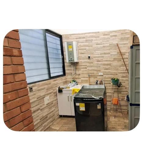 a kitchen with a sink and a brick wall at Casa totalmente amoblada in Yopal
