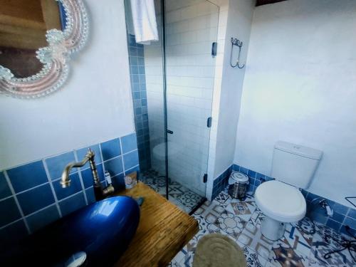 a blue bathroom with a toilet and a tub at De oio no arroio in Cambará