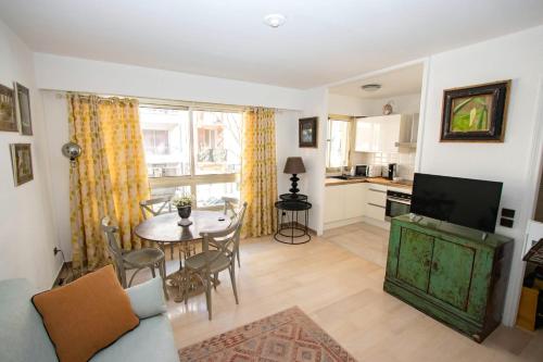 a living room with a table and a kitchen at Cap SOLEIL in Antibes