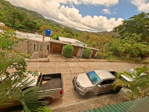 two cars parked in a driveway in front of a house at Casa Isabella 45 AC en las habitaciones in Matagalpa