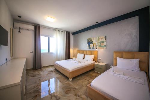 a hotel room with two beds and a window at Rumani 3 Islands Hotel in Ksamil