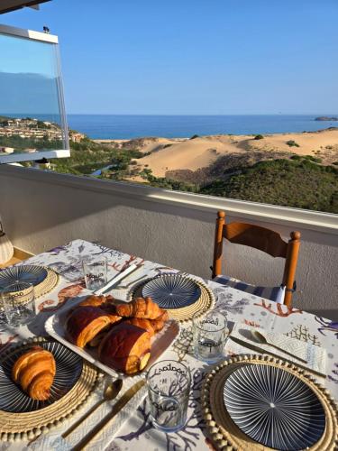 a table with a plate of croissants and a view of the desert at Golden Dune View in Torre Dei Corsari