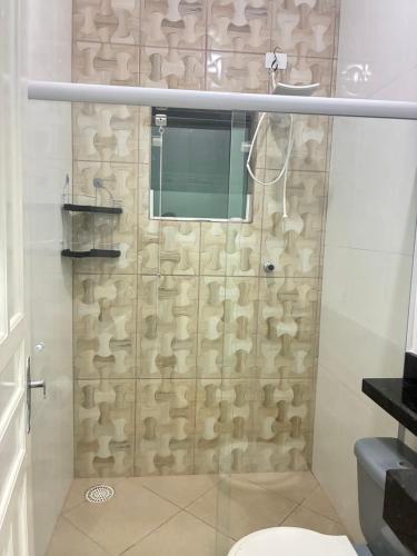 a bathroom with a shower with a glass door at Casa centro de Peruíbe in Peruíbe